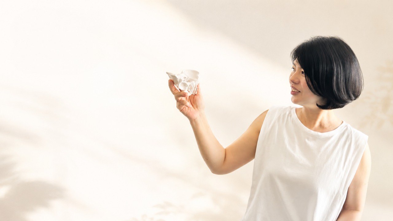 骨盤模型を手にする、山口ともみ